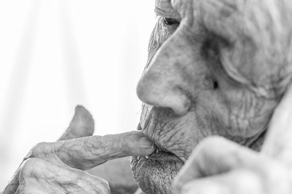 alte Frau pickt mit Finger Brotkrumen auf, Fotograf Mario Sornig